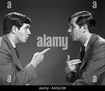 1960s MAN DOUBLE EXPOSURE TALKING TO HIMSELF POINTING Stock Photo