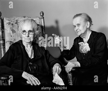 1940s 1950s TWO ELDERLY SENIOR WOMEN TALKING ONE POINTING Stock Photo
