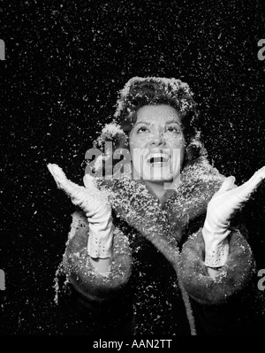 1950s WOMAN WEARING FUR COAT HAT AND GLOVES IN SNOW Stock Photo