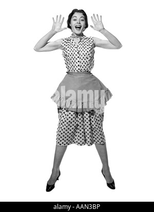 1950s WOMAN IN APRON JUMPING EXAGGERATED EXPRESSION LOOKING AT CAMERA Stock Photo