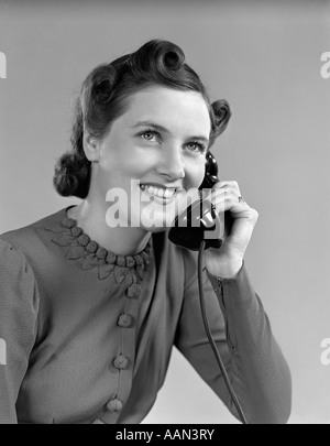 1940s YOUNG WOMAN SMILING TALKING ON TELEPHONE Stock Photo