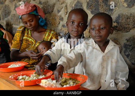 Displaced Congolese children eat mashed cassava at a feeding center run ...