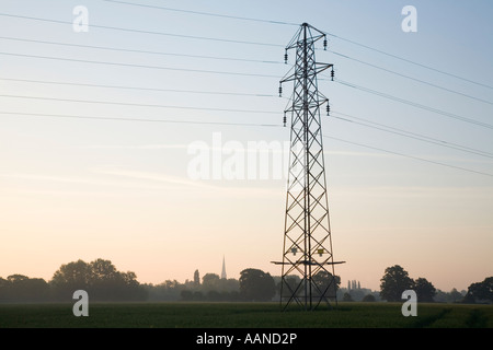 Electricity Pylon with the Spire of Salisbury Cathedral on the Horizon Wiltshire England Stock Photo