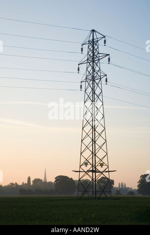 Electricity Pylon with the Spire of Salisbury Cathedral on the Horizon Wiltshire England Stock Photo