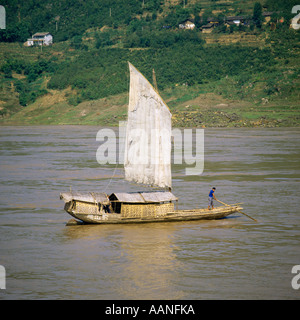Close-up of a man steering a traditional country sailing craft on the swirling rivers of the Yangtze River Sichuan China Stock Photo