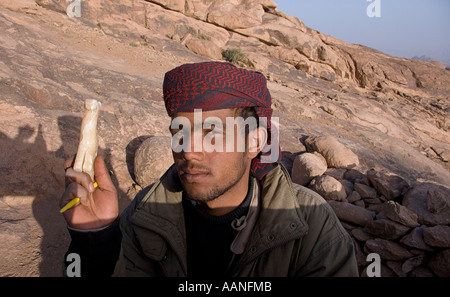 Sinai Egypt Bedouin vendor selling from his stall on the summit of Mount Sinai Holding a carved camel Stock Photo