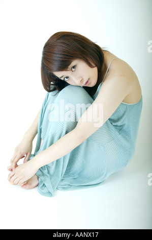 A young woman hugging her knees Stock Photo