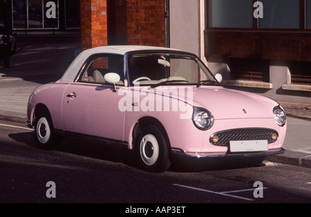 Nissan Figaro: Pink version of this 2 door canvas sun roof retro fashion car (1991) parked on a street in Covent Garden, London Stock Photo