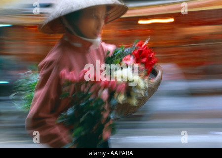 street scene a woman carrying flowers Hanoi Vietnam Stock Photo