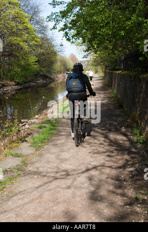 Cyclist on tow path besdie Huddersfield Narrow Canal at Slaithwaite Stock Photo