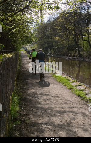 Cyclist on tow path besdie Huddersfield Narrow Canal at Slaithwaite Stock Photo