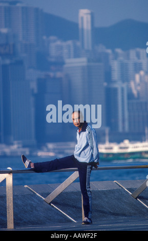 Hong Kong Man doing Tai Chi Chuan exercises Kowloon side. Hong Kong Island in distance China 1990s HOMER SYKES Stock Photo