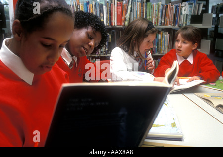 A group of students studying together working on their homework in the school library. Stock Photo