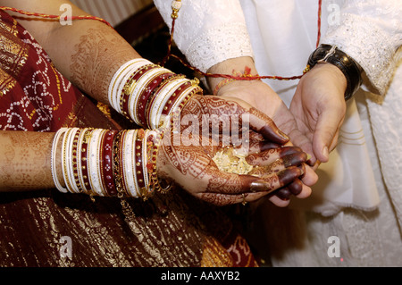 HMA70249 South Asian Indian Bride and Groom holding Rice in urban wedding marriage matrimony ceremony ritual India Stock Photo
