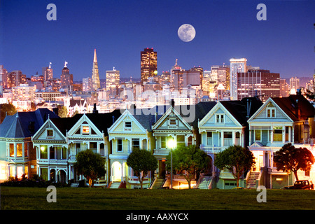 Seven Sisters Victorian houses at Alamo Park showing the San Francisco skyline at twilight in California Stock Photo