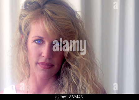 beautiful female model with full lips and blue eyes and blonde curly hair close up horizontal Stock Photo