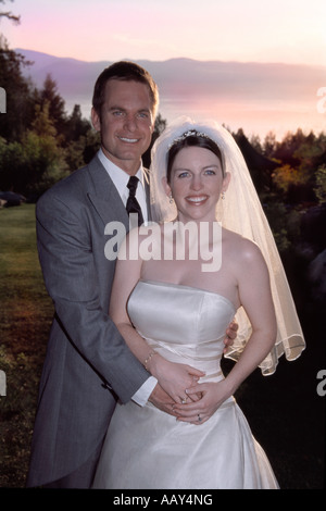portrait of bride and groom in love as newlyweds at wedding ceremony posing at sunset Stock Photo