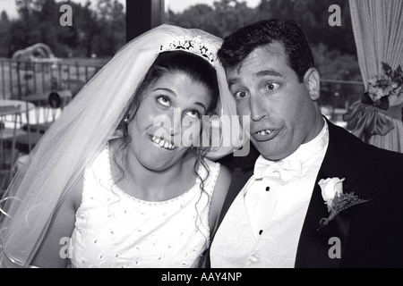 goofy couple at wedding making funny faces bride and groom happy silly horizontal black and white Stock Photo