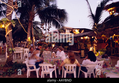 Restaurant in the evening at the beach of Cabarete People are sitting on plastic chairs Dominican Republic Stock Photo