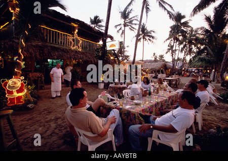 Evening light atmosphere in a restaurant where people are sitting near the beach of Cabarete Dominican Republic Stock Photo