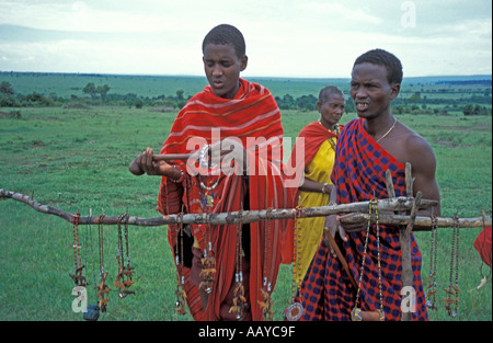 KENYA Masai Mara National Reserve Masai warriors in traditional red cloth arrange jewelry made by the Masai women for sale nea Stock Photo