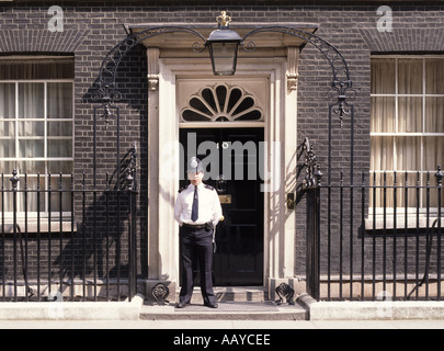 Number 10 ten Downing street front door & duty police officer summertime sunny day in shirt without jacket in City of Westminster London England UK Stock Photo