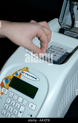 Loading a tube of DNA into a PCR (polymerase chain reaction ...