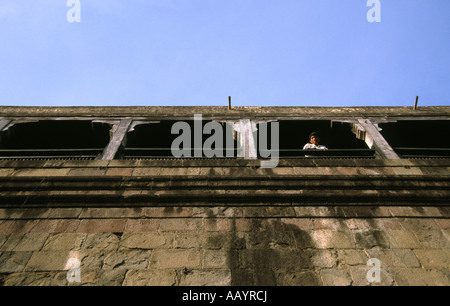 A man looking out of arches on top of a building in Pune, India Stock Photo