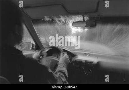 Looking through the windshield of car driving on road with blurred effect Stock Photo