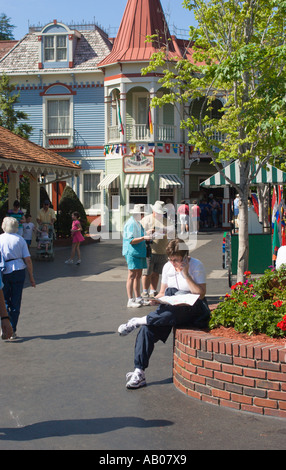 Woman talks on cell phone and studies map while planning day at Dollywood theme park in Pigeon Forge, Tennessee, USA Stock Photo
