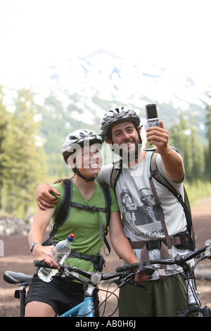 Couple on mountain bikes take a photo together with cell phone Stock Photo