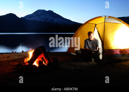 Man using laptop computer while camping Stock Photo