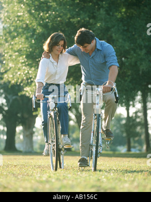 carefree couple riding bicycles in park Stock Photo