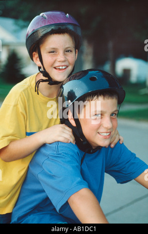 Boys in helmets riding bike Stock Photo