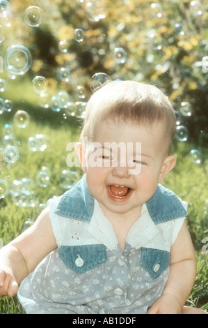 Baby catching bubbles outdoors Stock Photo