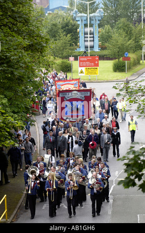 Workers and their families march under trade union banners and led by a brass band from Corus Ebbw Vale tinplate works Wales UK Stock Photo