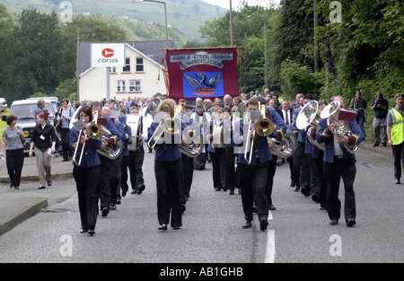 Workers and their families march under trade union banners and led by a brass band from Corus Ebbw Vale tinplate works Wales UK Stock Photo