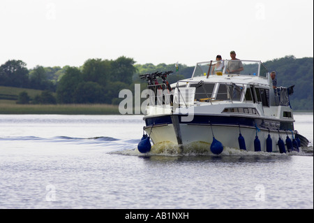tourists with bikes on deck pilot large cabin cruiser cruising along lower lough erne Stock Photo