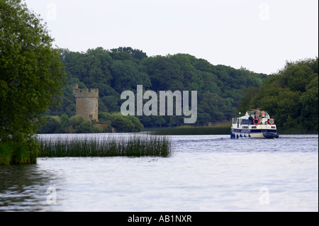 tourist cabin cruiser cruising towards Crichton Tower on Gad island part of the Castle Crom estate lower lough erne Stock Photo
