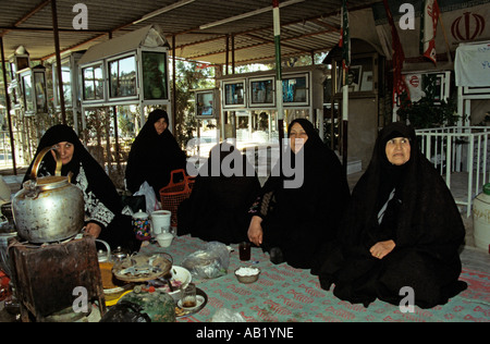 Family members mourn over loved ones that they lost in the Iran Iraq war at a cemetary in Tehran Stock Photo