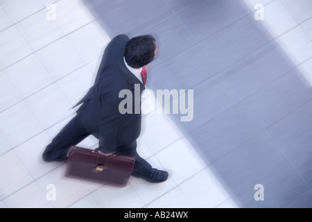manager in a suit walking with briefcase from above Manager im Anzug mit Aktentasche Stock Photo