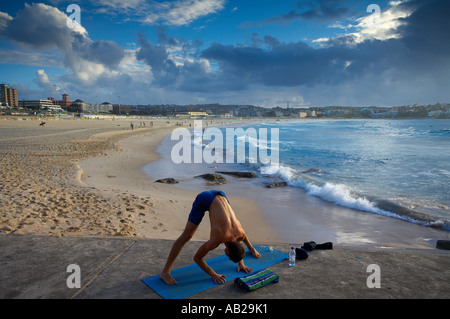 man doing exercises on Bondi Beach at dawn Sydney New South Wales Australia Stock Photo