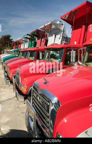 Bright red Mack dump trucks line the road in a row in Maine near the New Hampshire border Stock Photo