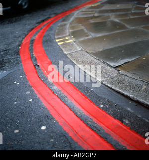 Double red lines on a bend in a road London UK  KATHY DEWITT Stock Photo