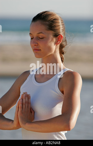 Woman on beach practising Yoga Stock Photo