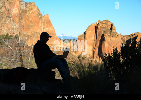 Silhouette of man using laptop outdoors Stock Photo