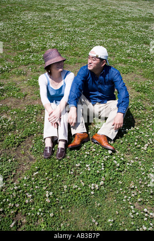Mature couple sitting on ground Stock Photo