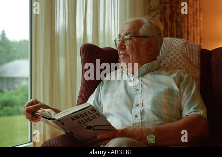 old man reading a book while waiting to go to the hospital for check up Stock Photo