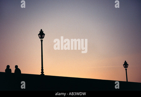 Couple talking on bridge at twilight Stock Photo