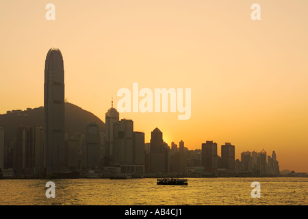 A sunset view of skyscrapers on Hong Kong Island over Victoria Harbour with the IFC building (tallest in Hong Kong) left. Stock Photo